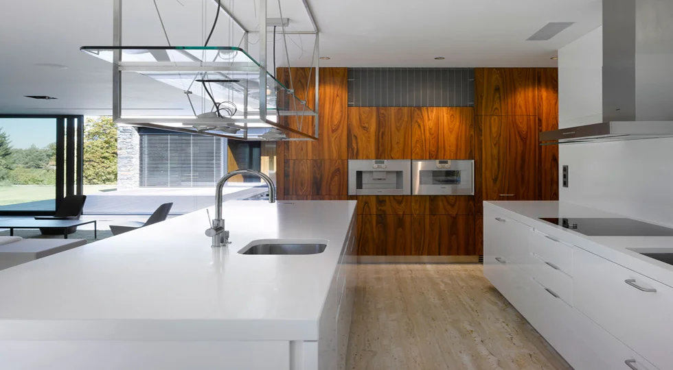 Bright contemporary kitchen with crisp white walls and warm wood cabinetry